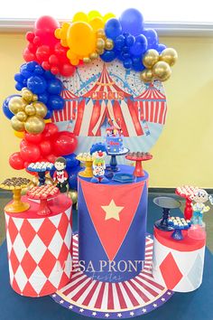 a circus themed birthday party with balloons and decorations on the top of a cake stand