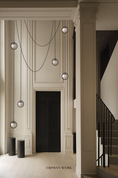 an empty hallway with chandeliers hanging from the ceiling and stairs leading up to it