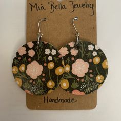 the earrings are decorated with flowers on black and pink background, along with words that read miabellafueling handmade