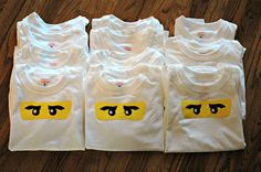 five white t - shirts with yellow eyes on them sitting on a wooden floor next to each other