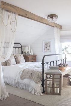 a bedroom with white walls and wooden beams