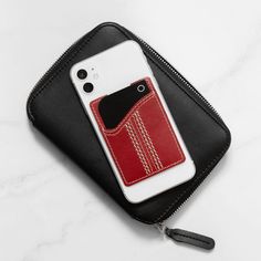 a cell phone case with a red pocket on the front and black zipper around it