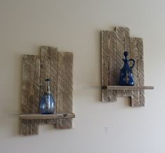 two wooden shelves with blue vases on them