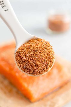 a spoon full of seasoning sitting on top of a piece of bread