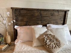 a wooden headboard with pillows and flowers on it