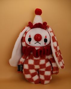 a red and white stuffed animal wearing a scarf