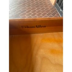 there is a wooden bench with the name finnn aller on it and brick flooring