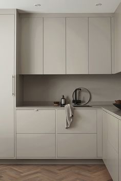 a kitchen with white cabinets and wood flooring