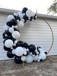 black and white balloons are arranged in the shape of a letter