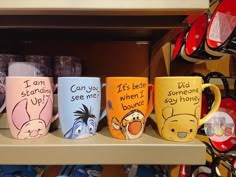 winnie the pooh coffee mugs are on display in a store with other items