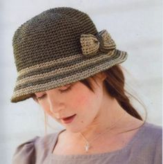 a woman wearing a crocheted hat with a bow on the front and side