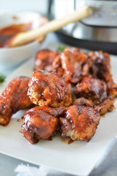 chicken wings covered in sauce on a white plate