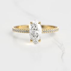 a yellow gold ring with a pear shaped diamond