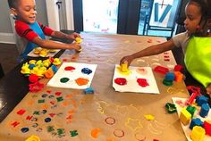 two children are playing with toys at the table