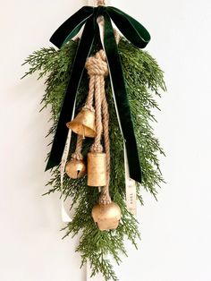 an evergreen wreath with bells hanging from it