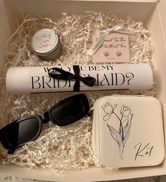 an open box containing sunglasses, a pair of glasses and a card