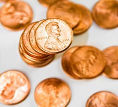 a penny is sitting on top of some other coins