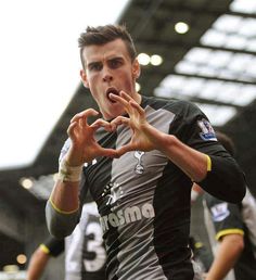 a soccer player is making a heart sign with his hands as he stands in front of other players