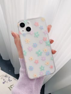 a person holding up a phone case with flowers on it