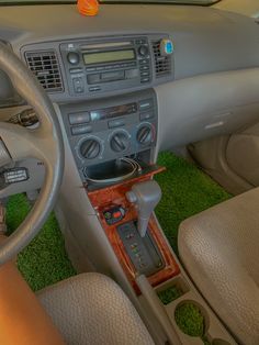 the interior of a car with an electronic console and steering wheel, including dashboard controls