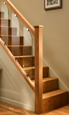 a wooden stair case with glass balconies on the bottom and handrails