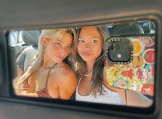 two women taking a selfie in the back seat of a car