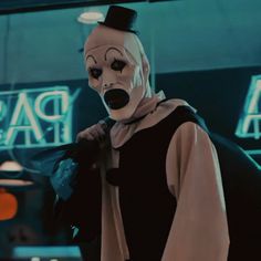 a man in a clown mask and black cape standing next to a sign that says pass