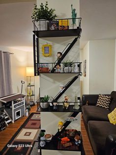 a living room filled with furniture and a tall metal shelf next to a brown couch