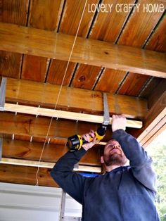 a man is working on the ceiling in his garage with a pair of pliers