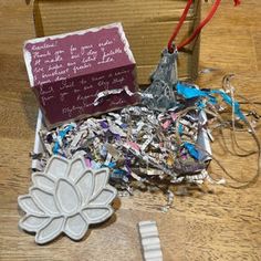 a pile of shredded paper sitting on top of a wooden floor next to a box