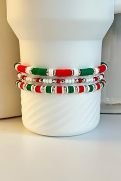 Celebrate the Christmas Holidays with a collection of red, white, and green beaded bracelets hand crafted to add personal style to your Stanley cup.  🌟 Great for gift giving, holidays, sports, parties, and everyday charm. 🌟 Set includes 3 bracelets designed to fit the 40oz Stanley Quencher with a silicone boot in place.  Tips & Care: - Will also fit the 20oz and 30oz Stanley cups with a silicone boot (not included) - Remove bracelets prior to washing tumbler. Not dishwasher safe. - Given the nature of elastic, stretching or breakage may occur overtime. Take care to avoid overstretching the bracelets when putting them on or taking them off. Stanley Charms Diy, New Years Bracelets, Winter Clay Bead Bracelets, Stanley Bracelet, Christmas Clay Bead Bracelets, Xmas Bracelets, Christmas Bracelet Ideas, Christmas Beaded Bracelets, Stretch Beaded Bracelets Diy