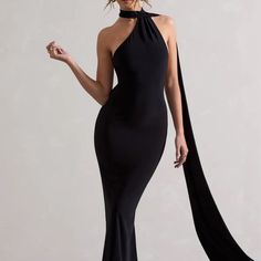 a woman in a long black dress with an open neck and high slits on the side