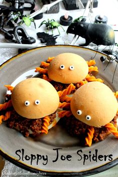 three sloppy joe spider sandwiches on a plate with fake eyes and googly eyes in the middle