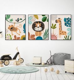 three children's art prints hanging on the wall above a playroom with toys