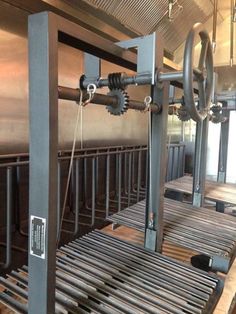 the inside of an industrial kitchen with metal pipes and racks on the wall, along with wooden flooring