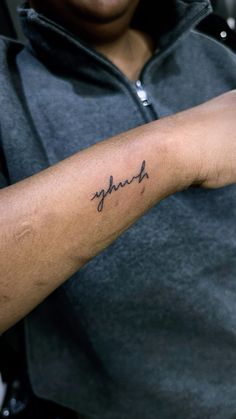 a person with a tattoo on their arm that says, faith in cursive writing