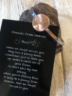 a penny sitting on top of a rock next to a poem