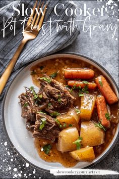 a white plate topped with stew and carrots next to a fork on top of a table