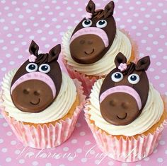 three cupcakes decorated with chocolate and white frosting have faces of horses on them