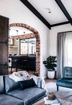 a living room filled with furniture and a brick wall