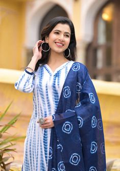 Grab this beautiful 3-piece set. The set comes with straight cut tie dye kurta has v neck, 3/4th sleeves & calf length teamed with printed trouser pants and a printed chanderi cotton dupatta to match. Color - Blue & White Kurta Fabric-Viscose Pant Fabric-Viscose Dupatta Fabric- Chanderi Cotton Neck-V Neck Sleeves-3/4th Sleeves Work - Tie Dye & Print Detailing Washing Instructions-Dry Clean Model Height - 5.5 wearing size small. DISCLAIMER - The color of the product may be differ due to screen se Cotton V-neck Set With Dupatta, Bandhani Print Straight Kurta Sets For Summer, Summer Bandhani Print Sets With Straight Kurta, Bohemian Indigo Straight Kurta Set, Traditional Indigo Sets For Summer, Indigo Long Sleeve Summer Sets, Festive Unstitched Batik Print Sets, Blue Bandhani Print Sets For Summer, Blue Bandhani Print Summer Sets