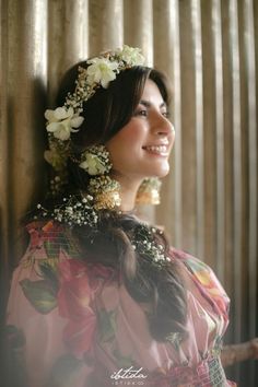 a woman with flowers in her hair smiling