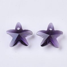 two purple star shaped beads on a white surface