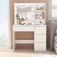 a white dressing table with lights on it and a mirror in the corner next to a couch