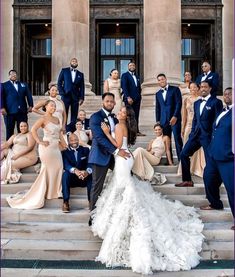 a group of people posing on steps in front of a building with the bride and grooms