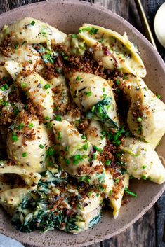 a bowl filled with pasta covered in sauce and parmesan sprinkles