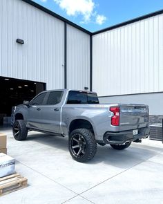 a silver truck parked in front of a building