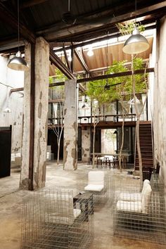 the interior of a building that has several cages in front of it with plants growing out of them