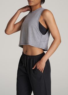 About Our Women's Tall Cropped Muscle Tank Having the right gear makes a difference. Everything about our athletic tank is made to help you smash your workout goals. Constructed with rayon and spandex, this tank won't slow you down. Our women's tall tank has been carefully crafted for women 5'9 to 6'6. Its cropped length ends just above the natural waist and its oversized armhole allows for maximum movement for a distraction-free workout. This athletic tank for tall women has been pre-washed and Cheap Camisole Tank Top For Workout, Cheap Collegiate Sports Tank Top, Woman Gym Outfit, Muscle Tank Outfit Women, Sleeveless Tshirt Outfit, Outfits For Muscular Women, Tank Top Outfits Aesthetic, Athletic Outfits For Women, Woman In Tank Top