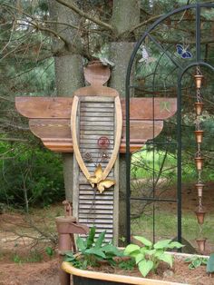 an outdoor fountain in the middle of a forest with plants growing out of it's sides